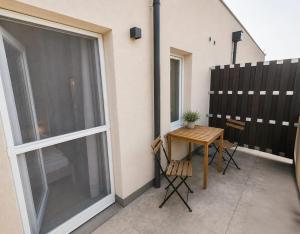 a small balcony with a table and a window at MarchfeldStay in Gänserndorf +4 photos