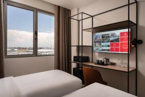 a hotel room with a bed and a window at Ibis Tashkent Index in Tashkent +87 photos