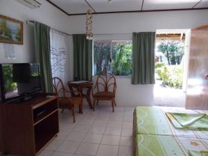 a living room with a television and a table and chairs at Marcosas Cottages Resort in Basdiot