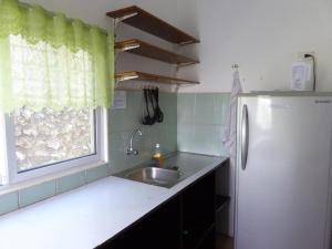 a kitchen with a sink and a refrigerator at Marcosas Cottages Resort in Basdiot