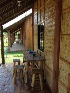 a porch of a log cabin with a table and two stools at calayo beach resort in Calayo +75 photos