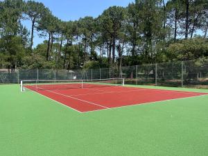 a tennis court with a net on top of it at Maison huit places Piscine tennis Lacanau plage in Lacanau