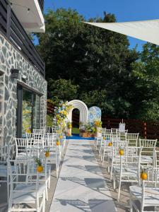 an aisle with white chairs and an arch at Ares Chalet in Horezu