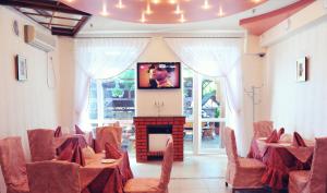 a room with a stage with chairs and a television at Hotel Koral in Chernivtsi +17 photos