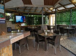a restaurant with tables and chairs and a flat screen tv at Immanuel Victory Hotel & Restaurant in Ajenkotoku