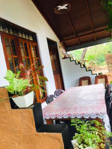 a table and chairs in a room with a staircase at Sigiri White Queen's Lodge in Sigiriya