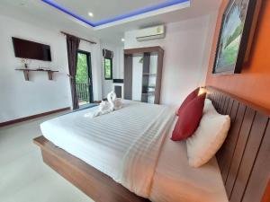 a bedroom with a large bed with red and white pillows at Lantanoblesse in Ko Lanta