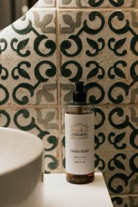 a bottle of hand soap sitting on a table next to a toilet at Hotel Pod Zeleným Dubem in Bohumín