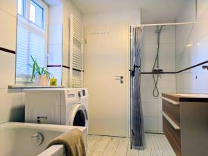 a bathroom with a tub and a washing machine at Hofidyll Burg - ruhige 75qm FeWo im Zentrum mit Terrasse & Biergarten - bis 6 Personen in Burg +17 photos