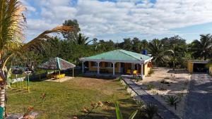 a small house with a green roof in a yard at Le tournesol Belle villa in Maroantsetra Airport