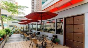 an outdoor patio with tables and chairs and umbrellas at Hotel HD Palace in Taipei