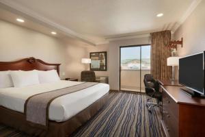 a hotel room with a bed and a desk with a television at Days Inn by Wyndham Eureka CA in Eureka