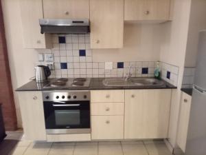 a small kitchen with a stove and a sink at Native Suites 411 in Johannesburg