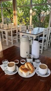 a table with plates of food and cups of coffee at Rio Termal in Federación