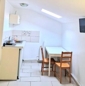 a small kitchen with a table and two chairs at Titulescu Apartments in Bucharest +11 photos