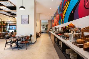 a restaurant with a long counter with tables and chairs at Ibis Tashkent Index in Tashkent