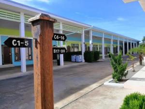 a pole with street signs in front of a building at Cindia Resort in Phun Phin