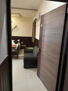 a door leading into a living room with a chair at Hotel Corbett Inn in Rudrapur