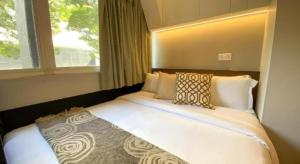 a bed sitting in a room with a window at ST Signature Bugis Beach in Singapore +172 photos
