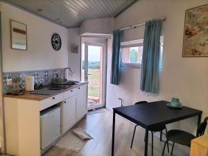 a kitchen with a sink and a table and a window at Chemin de Bizous in Montoussé