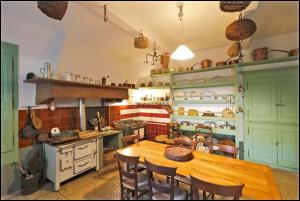 a kitchen with a wooden table and a kitchen with a stove at Maison Emile Teissier in Vébron