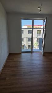an empty room with a large window and wooden floors at Apartmán Topolová 1146 in Milovice