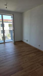 an empty room with a wooden floor and a sliding glass door at Apartmán Topolová 1146 in Milovice