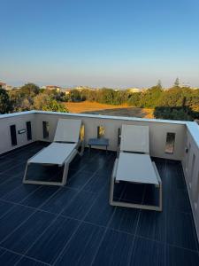 a balcony with two tables and chairs on a roof at Villa Velvet Chios in Chios