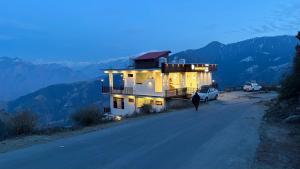 a person walking down a road next to a building at Grand Kailash view homestay -near Khajjiar in Dalhousie