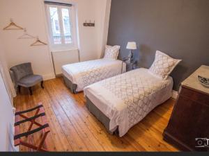 1 dormitorio con 2 camas, silla y ventana en VILLA treize quartier balnéaire en Mers-les-Bains
