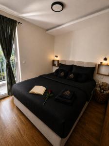 a bedroom with a large black bed with flowers on it at Lenka Lux Apartmans in Divčibare