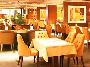 a dining room with yellow chairs and tables at The Clipper Hotel in Dongguan