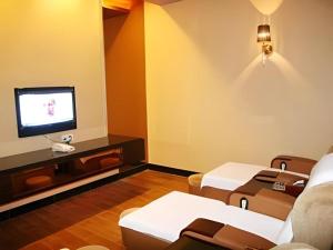 a living room with a couch and a tv at The Clipper Hotel in Dongguan