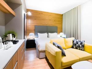 a hotel room with a bed and a yellow couch at Avior Hotel in General Santos +58 photos