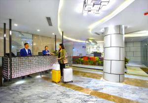 Eine Gruppe von Menschen steht in der Lobby eines Flughafens. in der Unterkunft Grace21 Runway Hotel in Dhaka