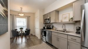a kitchen with a sink and a table with chairs at Kinze Apartment in Twistringen