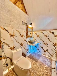 a bathroom with a toilet and a sink at Azhani Bungalow in Tetebatu