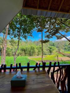 a wooden table with a view of a forest at Azhani Bungalow in Tetebatu