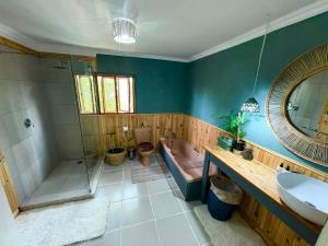 a bathroom with a shower and a sink and a tub at Elephant loft in Stormsrivier +8 photos