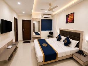 a bedroom with a large bed and a television at TRPOTELS Formerly Hotel Sagar in Gwalior