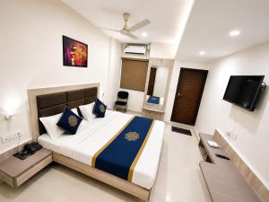 a bedroom with a large bed and a tv at TRPOTELS Formerly Hotel Sagar in Gwalior