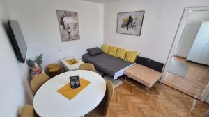 a living room with a table and a couch at InOsijek- FEELS LIKE HOME in Osijek