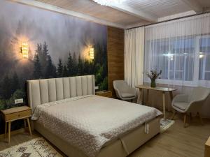 a bedroom with a bed and a painting on the wall at Bukovets' in Yaremche +131 photos