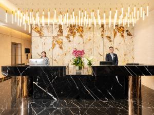 two people sitting at a desk in a lobby at G8 Center Hotel Saigon in Ho Chi Minh City +120 photos