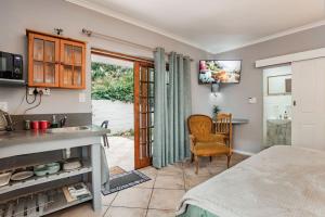 a kitchen with a bed and a sink and a table at Santa Stay in Stellenbosch