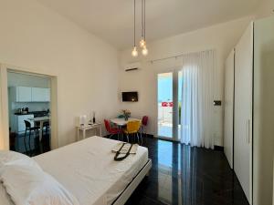 a bedroom with a bed and a table with chairs at Villa Nauna - Beachfront Villa with Garden & Sea-View Terrace Santa Caterina - Marea Stays Collection in Nardò