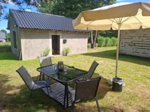 a table and chairs under an umbrella in a yard at DOMEK na górce u Celiny in Dargobądz