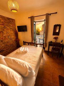 a bedroom with a bed and a table and a window at Diaks Tower Sunset Sea View Mani in Pyrgos Dirou