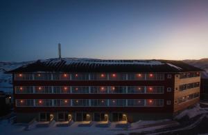 a building in the snow with lights on it at Hotel Arctic in Ilulissat
