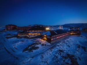 a building in the snow at night at Hotel Arctic in Ilulissat